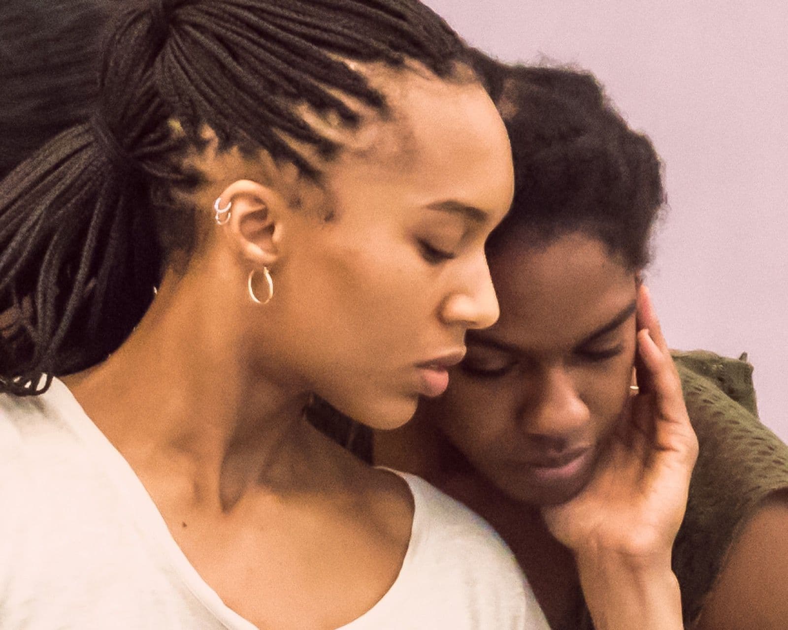 Close-up of dancers Catherine Kirk and Kayla Farrish leaning together with gentle expressions.