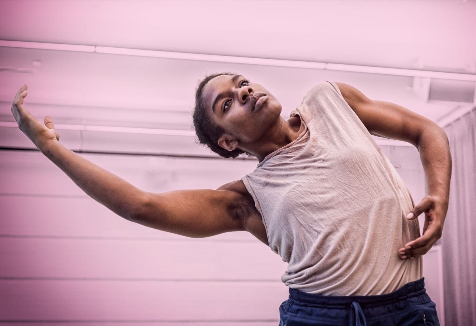 Dancer Kayla Farrish arching her upper body back with arm outstretched during a performance.