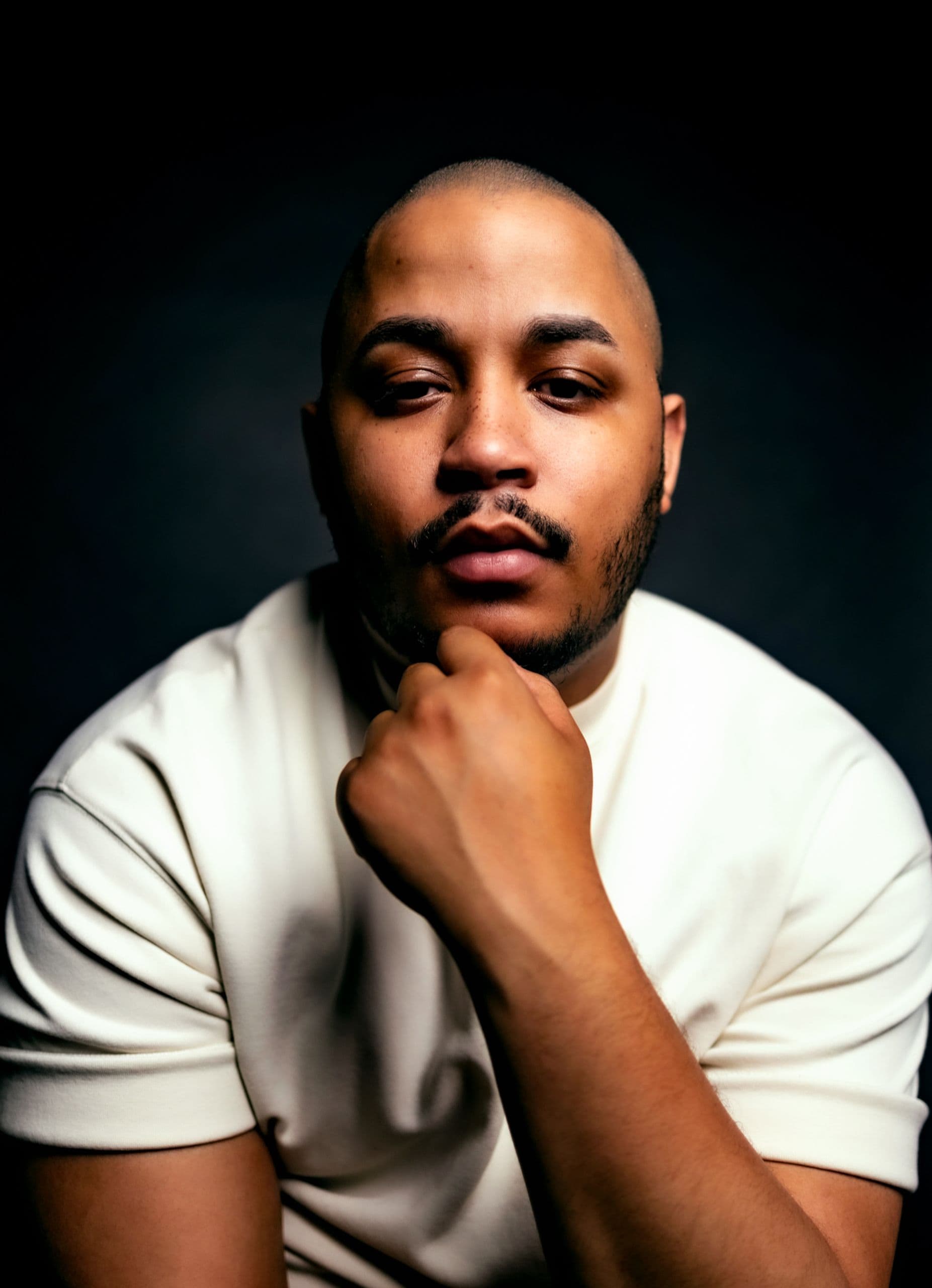 Alexander Diaz stands in front of a black backdrop.