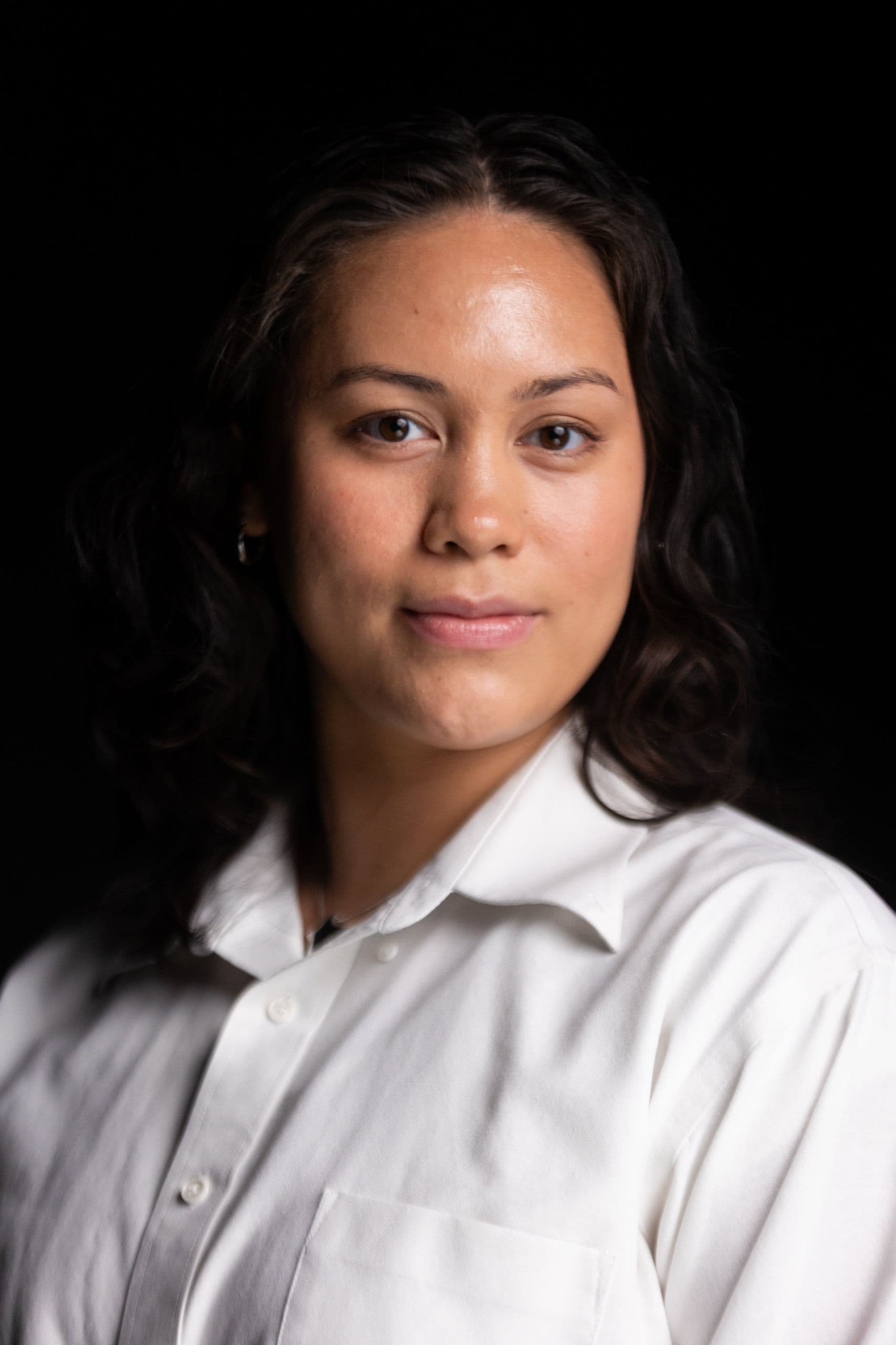 Mic stands in front of a black backdrop as they pose for a portrait.